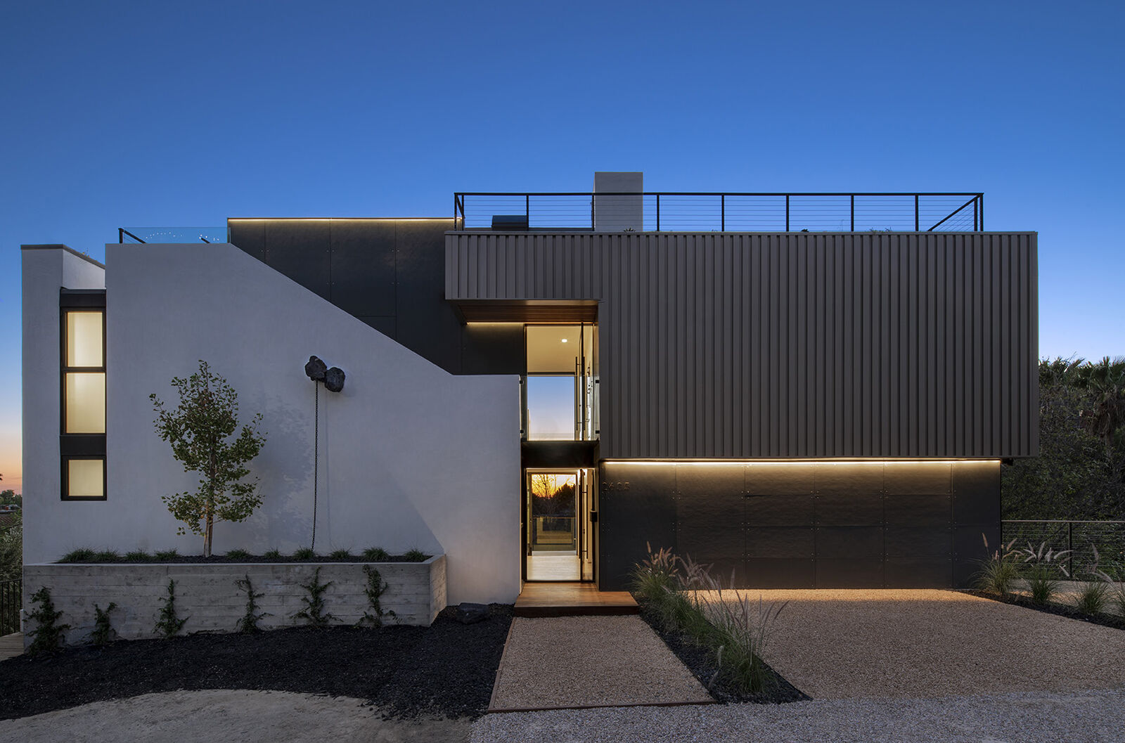 ALPICE home at dusk: a modern house with linear light under its overhangs