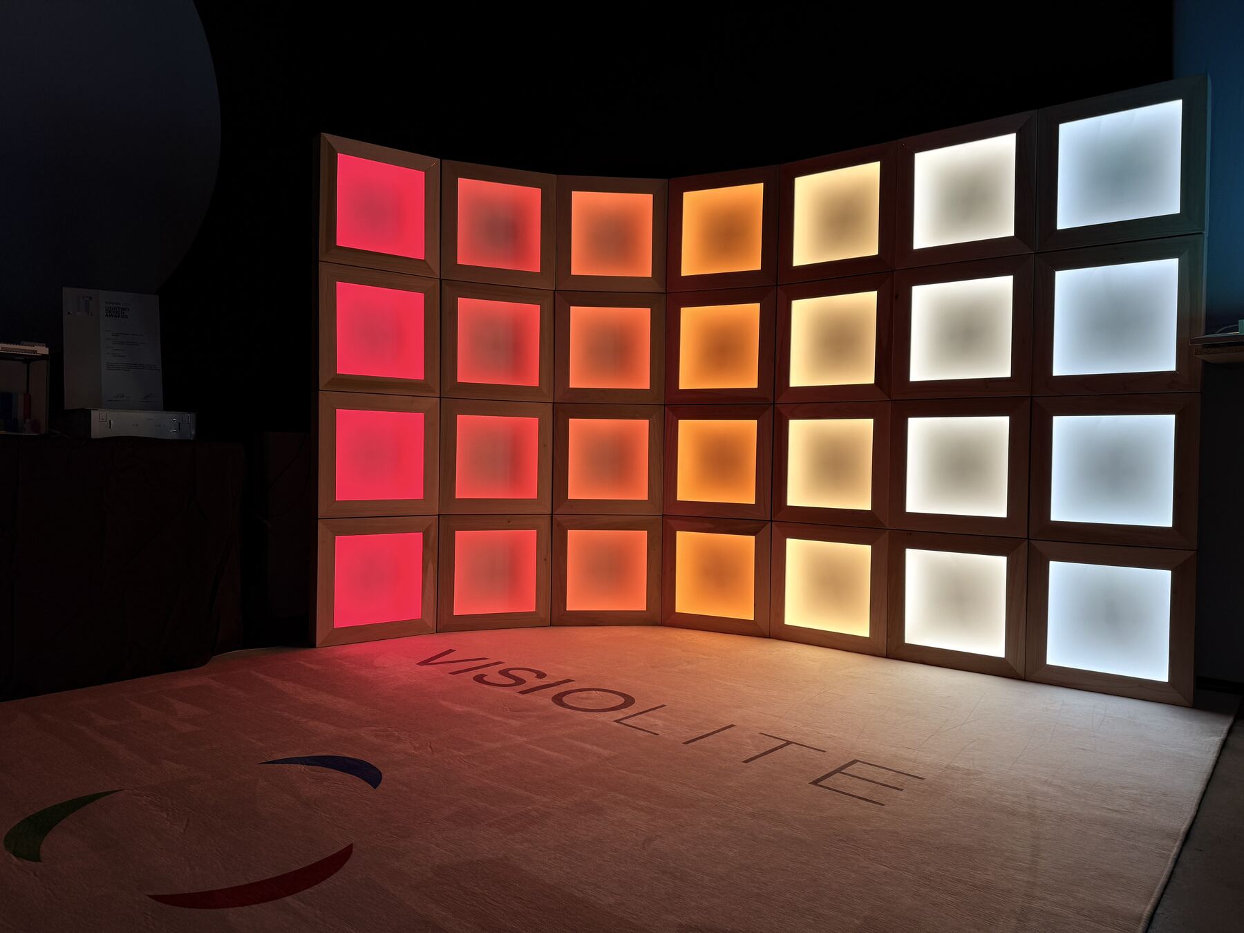 Celestial Echo Matrix: a curved wall of square light boxes from deep red through amber to cool white